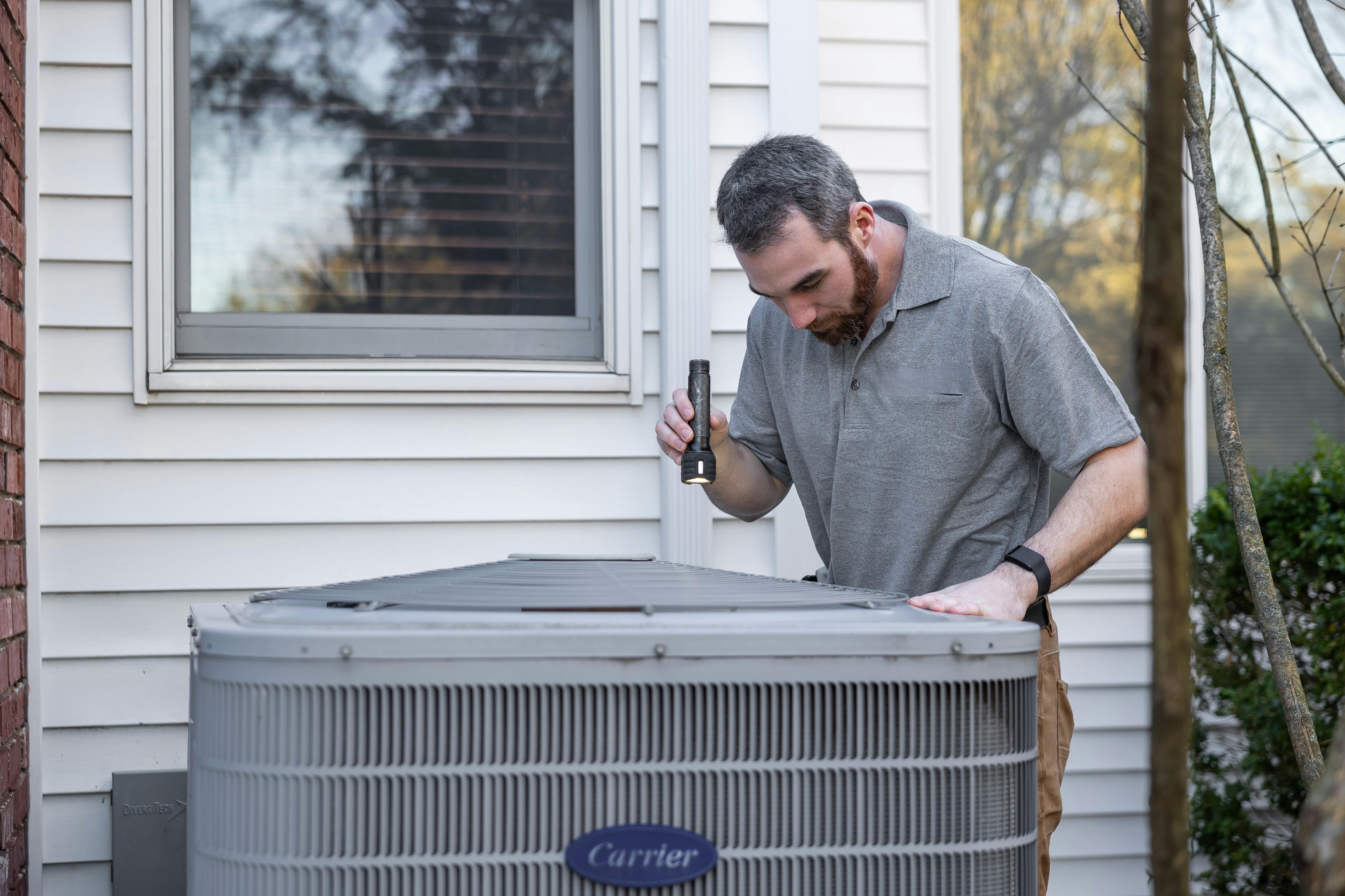 Professional HVAC technician servicing Carrier air conditioning unit in Berkeley, California